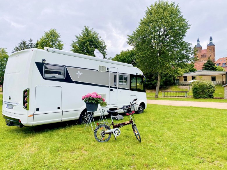 View of a mobile home on the caravan site of the Hanseatic town of Seehausen (A.), in the background the towers of St. Petri Church Seehausen (A.)