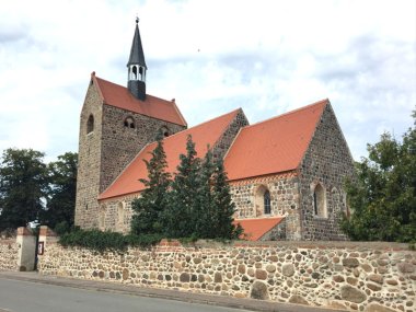 View over the church wall towards the village church in the Bretsch district