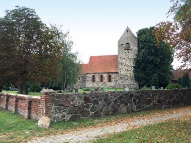 View over the church wall towards the village church in the district of Kossebau