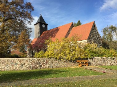 View over the church wall towards the village church in the district of Kossebau