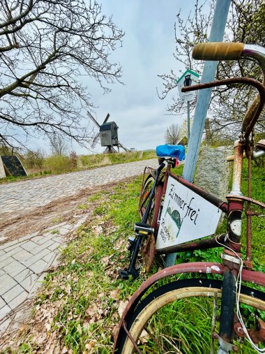 Blick auf die Mühle in Wanzer mit Fahrrad im Vordergrund und dem Hinweis Zimmer frei.
