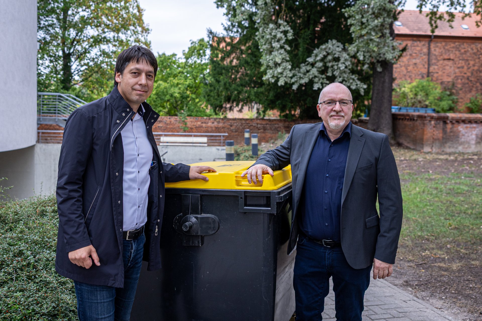 Patrick Puhlmann (links) und Hendrik Galster symbolisch an der Gelben Tonne