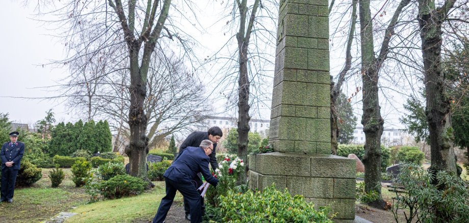 Steffen Jorns (vorn) und Patrick Puhlmann legen gemeinsam einen Kranz nieder